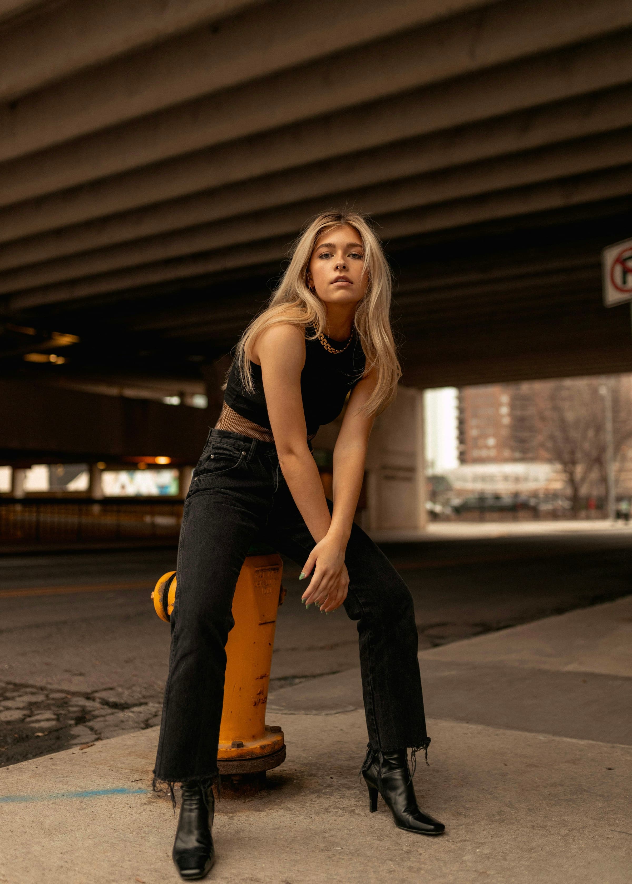 Street-style portrait of a woman seated on a fire hydrant