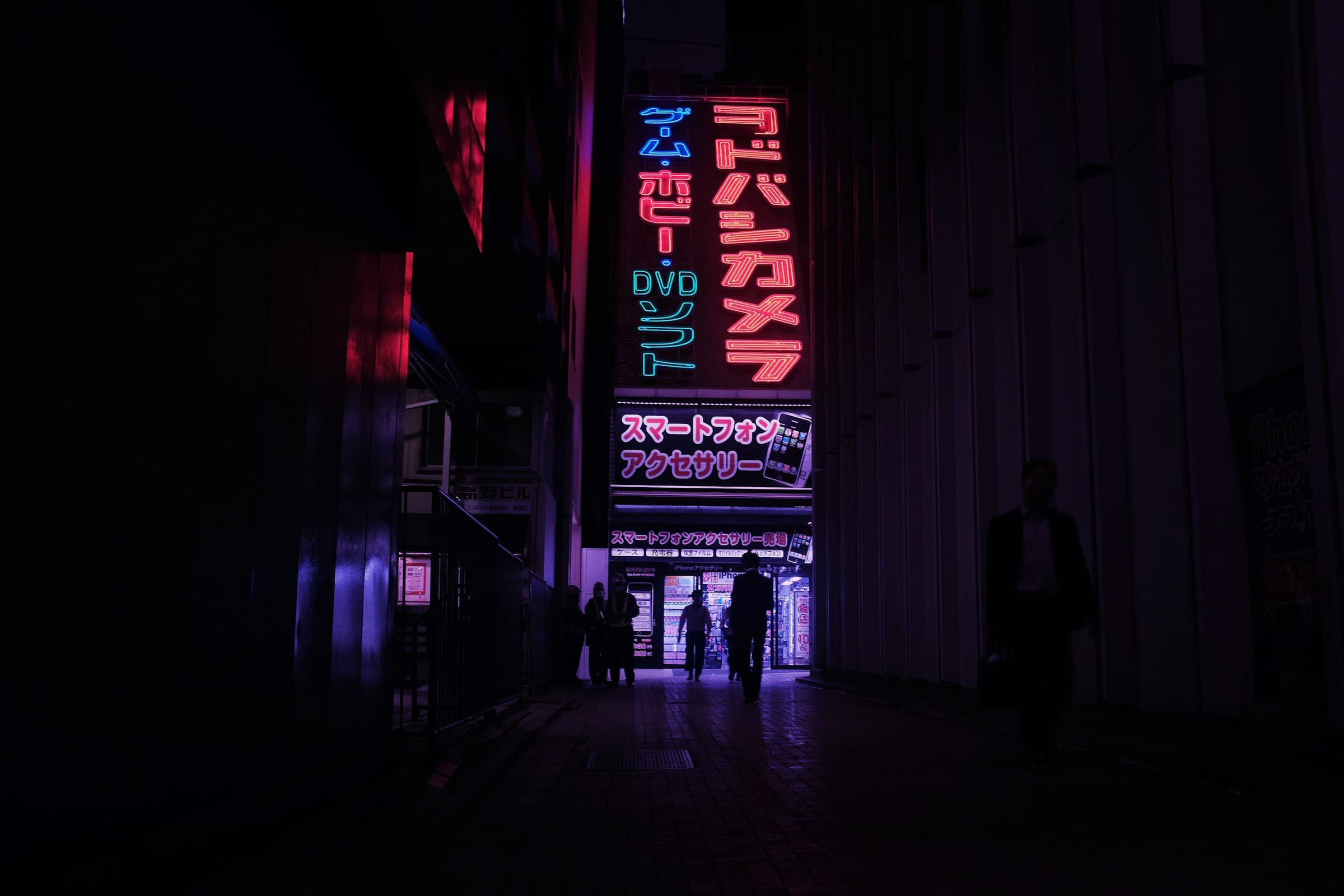 Pedestrians crossing between two high-rise towers, shot from street level