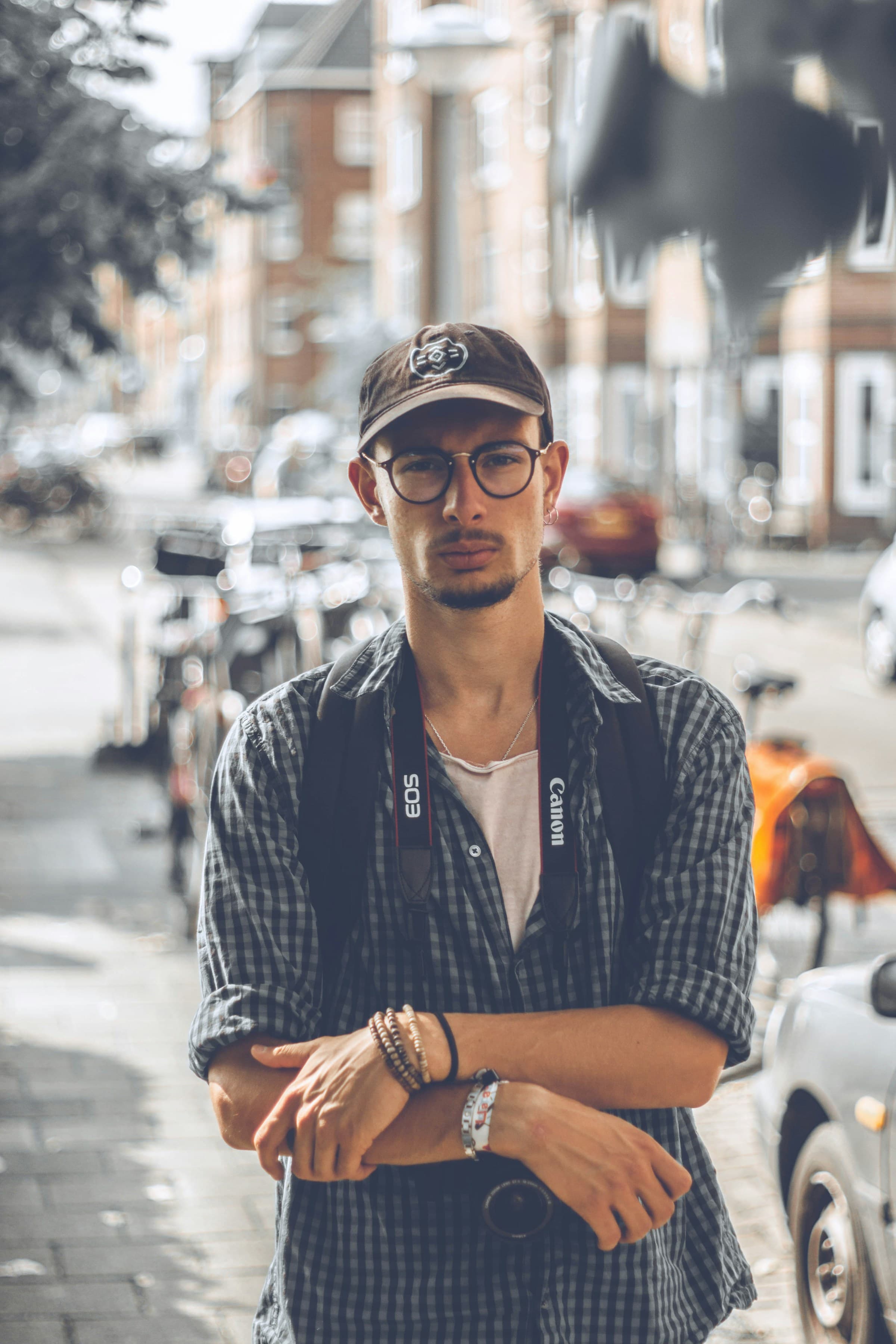 Campaign frame of a figure standing beside a parked car on an empty street